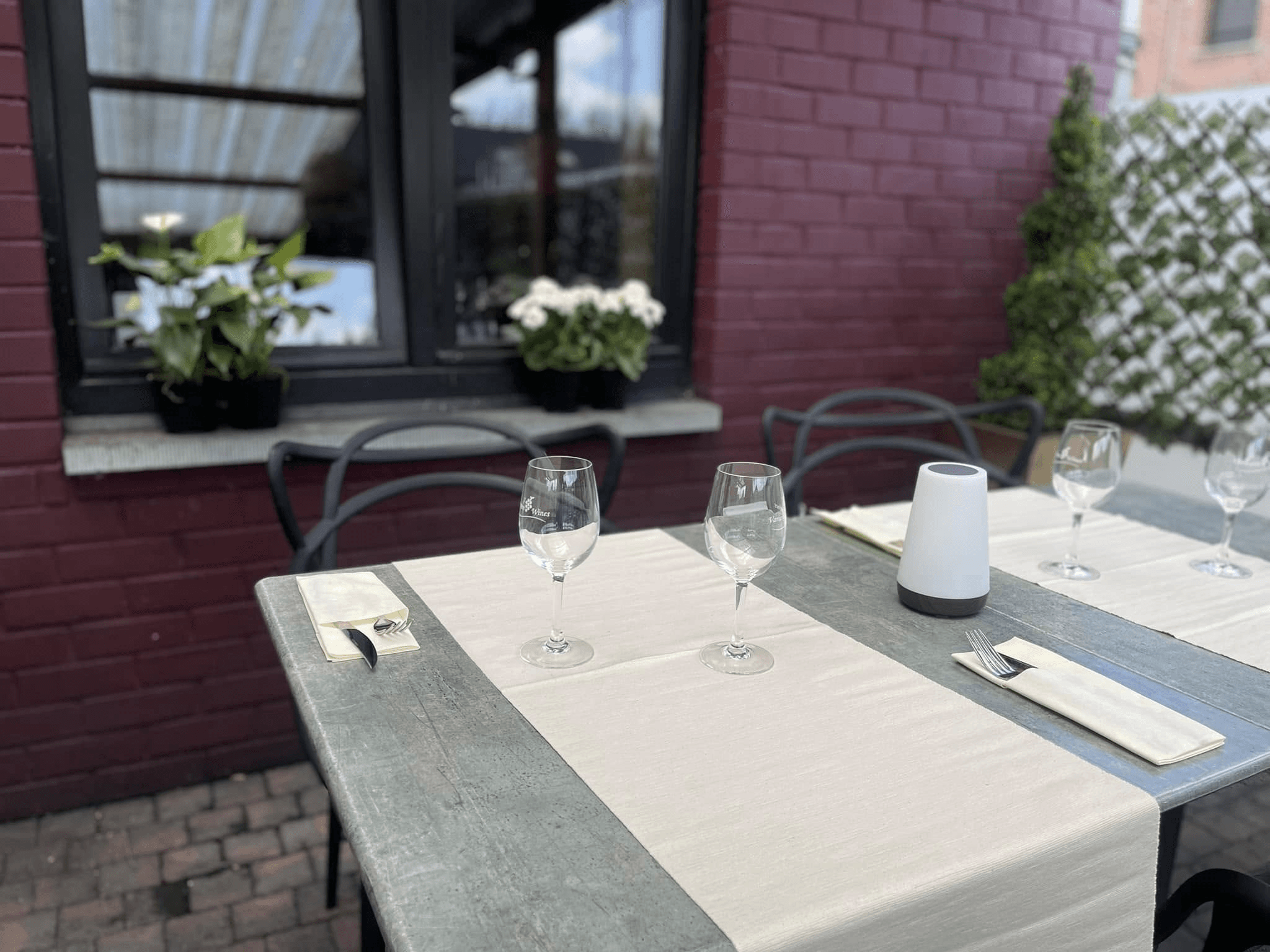 Tables dressées en extérieur devant la façade en briques
